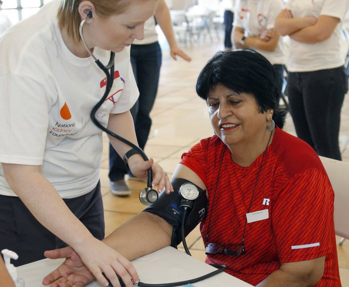 An attendee gets her blood pressure checked during the “Path to Wellness” free health fair.